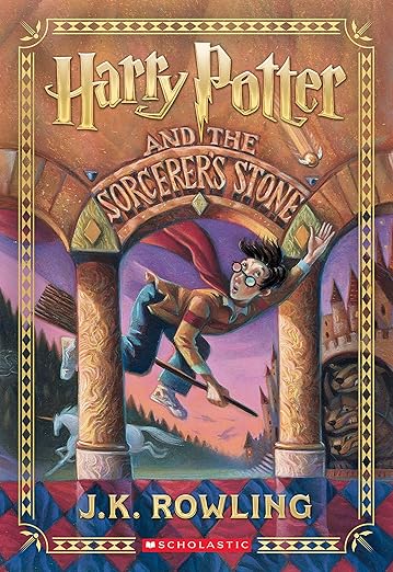 Harry Potter and the Sorcerer's Stone by J.K. Rowling book cover, depicting a boy wearing glasses and a yellow and red sweater flying on a broom between two beige pillars. He is attempting to grab the golden snitch, a small gold ball with wings. "Harry Potter" is written in gold letters at the top while "and the Sorcerer's Stone" is a part of the wall that the pillars are holding up. In the background are various magical creatures, a gradient purple sky, a castle, and a forest.
