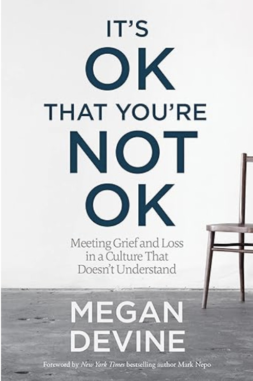 "It’s OK That You’re Not OK" by Megan Devine, a minimalist cover in shades of gray with a lone chair against a wall, underscoring the subtitle “meeting grief and loss in a culture that doesn’t understand.”