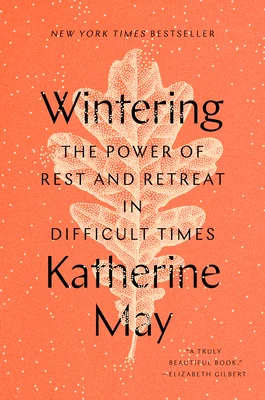 Wintering by Katherine May book cover. Depicts a salmon colored background with a white leaf.