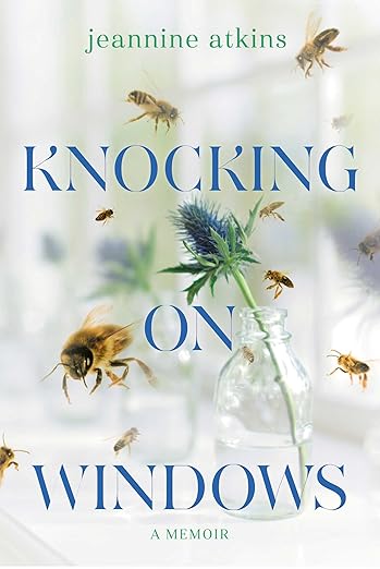 Knocking on Windows by Jeannine Atkins book cover, depicting a vase with a blue flower inside surrounded by flying bees. The background is out of focus but depicts a window with white frames. The title is in blue letters across the middle of the book cover.