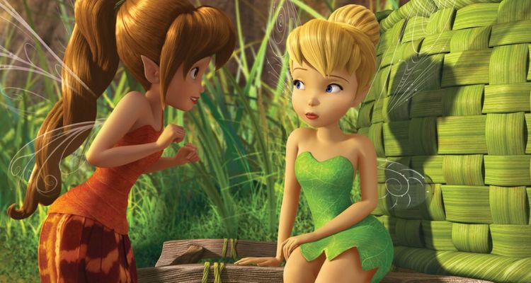 Still from Tinker Bell and the Legend of the NeverBeast, depicting Tinkerbell sitting down and looking at Fawn as she smiles at her. Behind them is tall, green glass, and a woven basket.