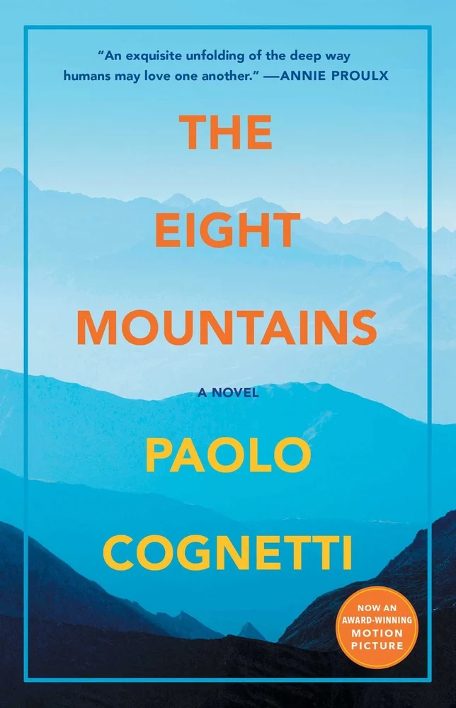 The Eight Mountains by Paolo Cognetti book cover. Depicts a mountain range in various shades of blue.