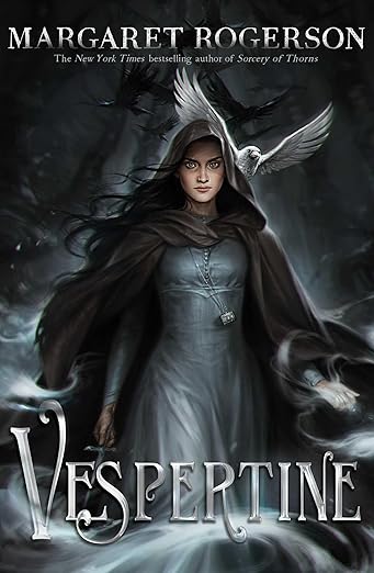 Vespertine by Margaret Rogerson book cover, depicting a woman in a grey-blue dress and dark brown coat with a fierce look on her face. Behind her is a white bird and a dark background. There is grey smoke around her hands and towards the bottom of the book cover. The title is written in silver letters at the bottom of the cover.