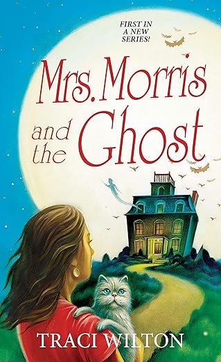 Mrs. Morris and the Ghost by Traci Wilton book cover, depicting a woman in a red shirt holding a cat looking at a house on a hill. There is a ghost coming out of one of the windows, and in the background is a bright, large moon and bats. The title is written on the top half of the moon in red letters.