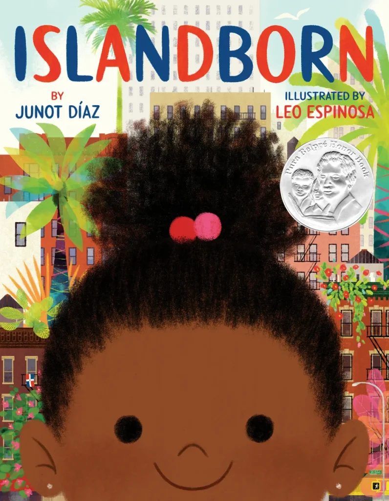 Islandborn by Junot Díaz and illustrated by Leo Espinosa, a picture book cover shows a cheerful, dark-skinned girl with a bun framed by colorful city buildings and tropical leaves.