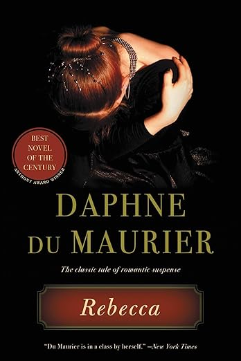 Rebecca by Daphne du Maurier, depicting an image woman hugging herself taken from above. Only her ginger hair, back, and hands are visible. She seems to be wearing a black dress. The title is in a red square at the bottom of the cover, while the author's name is in dark yellow large font towards the center of the cover.
