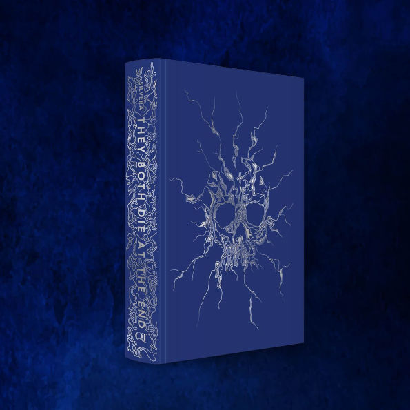 Deep blue hardcover case for the collector’s edition of “They Both Die at the End,” featuring a silver foiled skull design made of branching roots or veins.