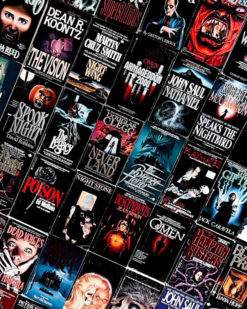 Depicts photo filled with various dark horror books with vintage paperback covers filling the entire frame.