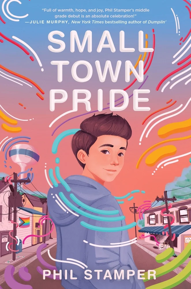 Small Town Pride by Phil Stamper, a young adult book cover depicting a cartoon illustration of a boy in a blue hoodie looks over his shoulder under the title in white text. Colorful lines swoop around the boy and the background of his neighborhood on a sunset sky.