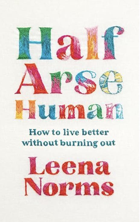 “Half Arse Human” by Leena Norms, a white cover with the title in bold, rainbow-colored embroidered lettering and a subtitle.