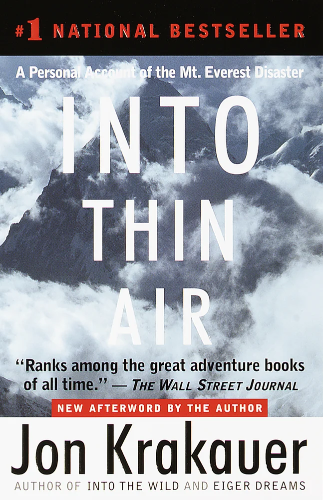 Into Thin Air by Jon Krakauer book cover depicts the peaks of Mount Everest ominously covered in clouds.