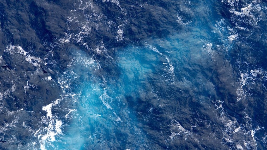 White waves rippling across a dark blue ocean.