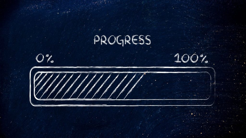 Chalk-drawn progress bar on a dark chalkboard background, marked from 0% to 100%. The bar is partially filled with diagonal lines, symbolizing ongoing progress.