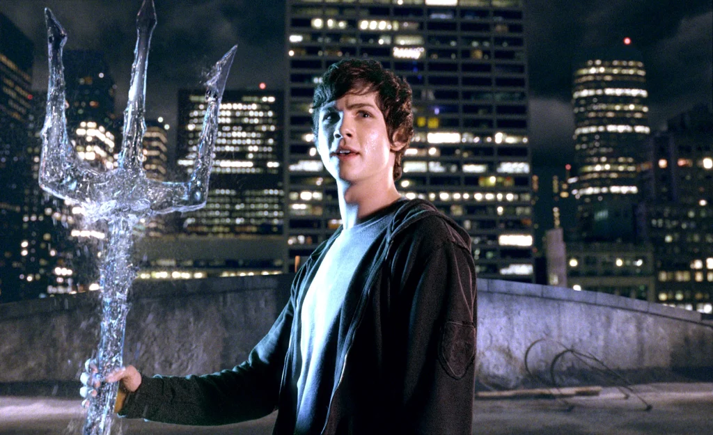 Logan Lerman as Percy Jackson, holding a glowing trident stands on a rooftop at night. City skyline with illuminated skyscrapers in the background. Confident, adventurous mood.