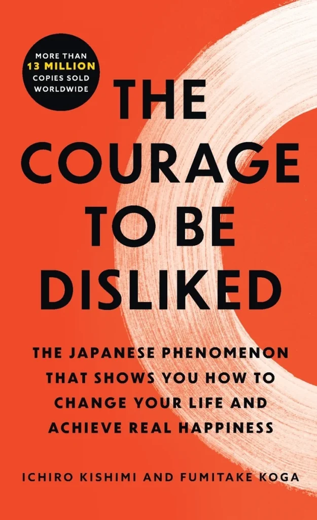 The Courage to Be Disliked by Ichiro Kishimi and Fumitake Koga, a self-help book cover depicting a red background with half of a white painted circle.