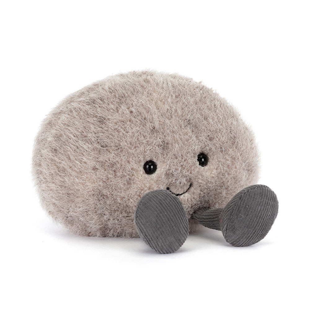 A fluffy, light gray plush toy shaped like a pebble with small, round eyes and a smiling face. It has soft gray feet, creating a cute and playful feel.
