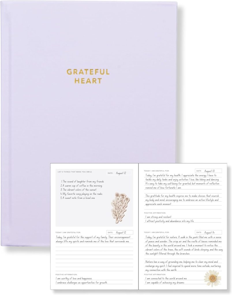 Lamare Daily Gratitude Journal for Women, a journal cover with the words "Grateful Heart" in gold against a purple background hardcover. There is an open journal displayed, with writing and floral stickers.