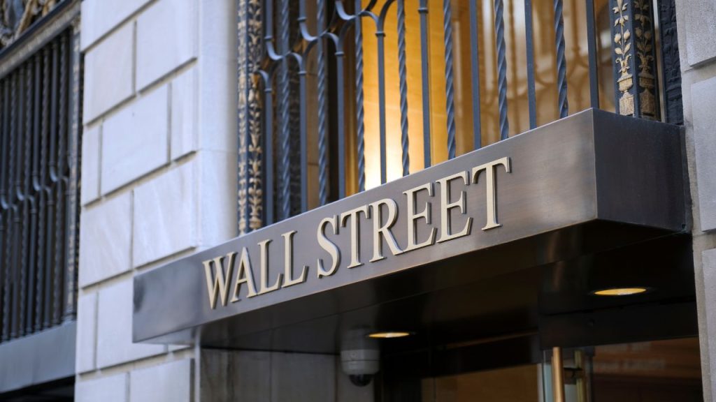 A metal awning beneath an ornate window grate in a white building; the awning reads "Wall Street."