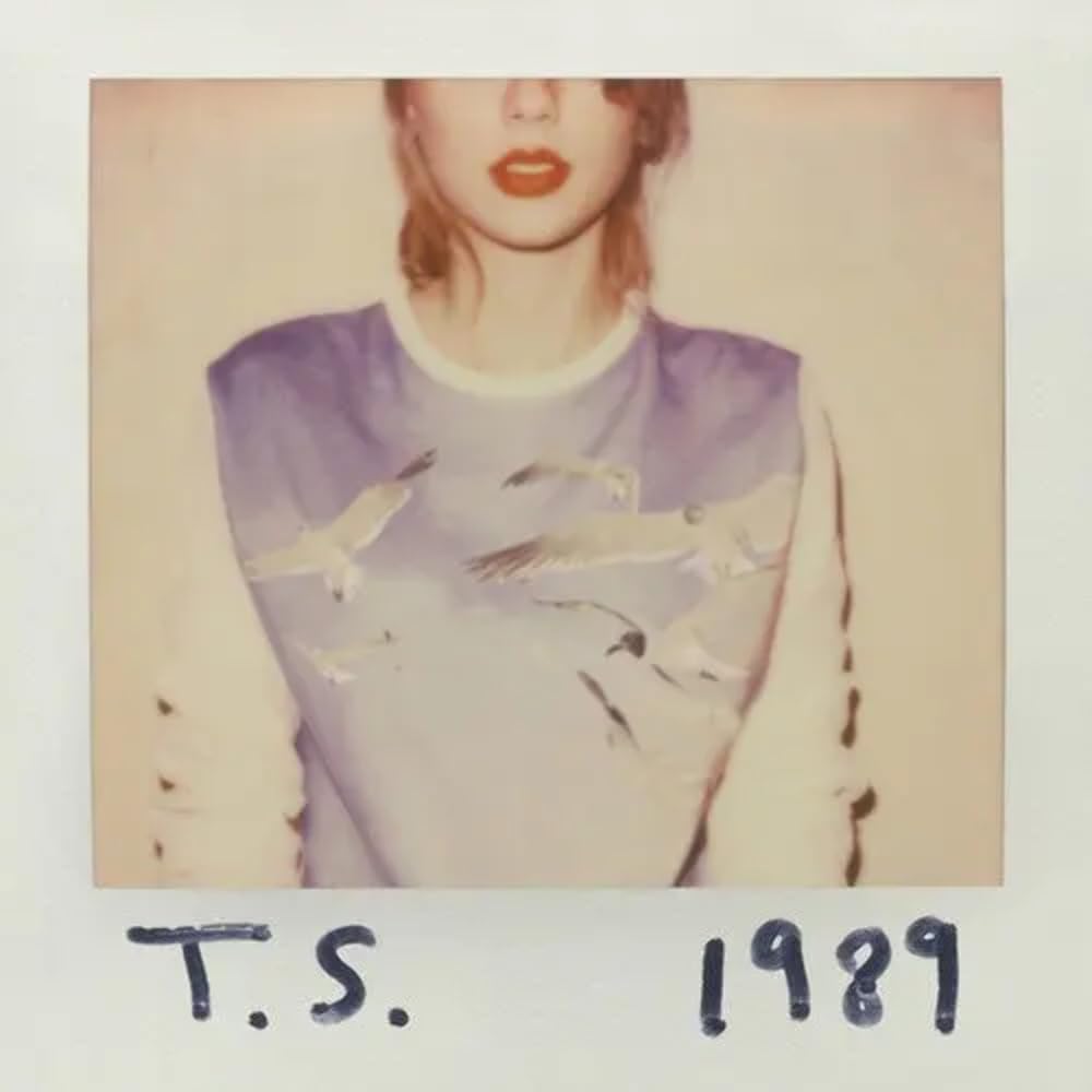 The album cover for 1989 by Taylor Swift. A faded Polaroid picture of Taylor Swift wearing a printed sweatshirt featuring white seagulls flying against a blue sky.