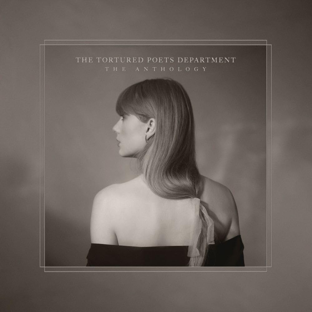 The album cover for The Tortured Poets Department: The Anthology by Taylor Swift. In black and white, Taylor Swift is featured from behind with her head turned to the left. She wears a black off-the-shoulder top, and her long hair is pulled loosely into a ribbon at the end of her hair.