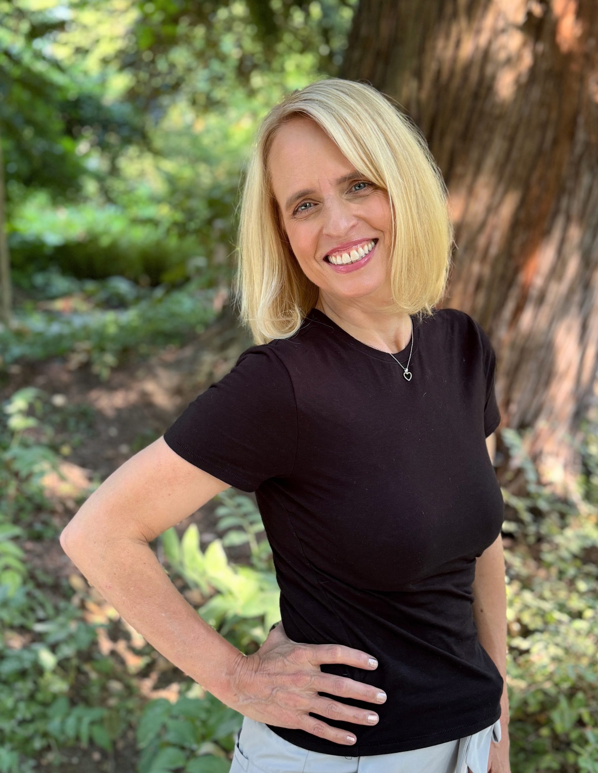 Romance Author Lauren Blakely smiling at the camera while outside.